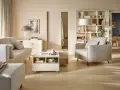 Nowoczesny salon z beżową kanapą, fotelem, stolikiem kawowym i regałem.