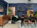 Elegancka jadalnia w odcieniach **kolor navy**. Drewniane meble, aksamitny fotel i nowoczesne oświetlenie tworzą przytulną atmosferę.