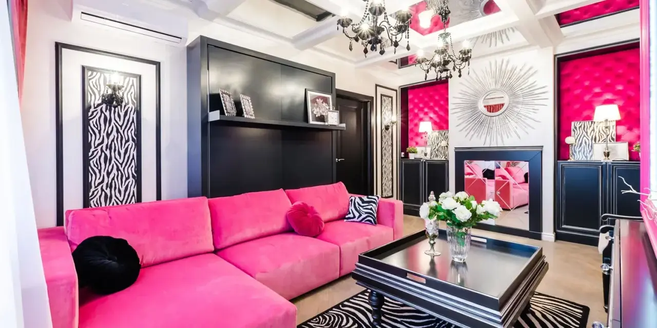 Nowoczesny salon z fuksjową kanapą. Czarny stolik i dywan w zebrę podkreślają, jaki kolor pasuje do fuksji.
