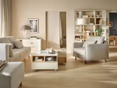 Nowoczesny salon z beżową kanapą, fotelem, stolikiem kawowym i regałem.