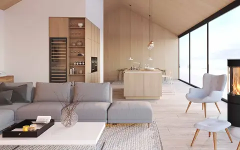 Jasny, przestronny salon z aneksem kuchennym w stylu skandynawskim. Drewniane wykończenia, duża sofa i kominek tworzą przytulną atmosferę.