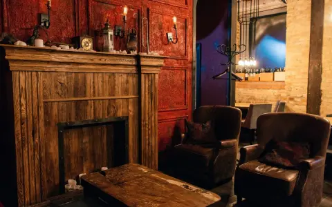 Drewniany kominek, skórzane fotele i lampy tworzą atmosferę **steampunk**.