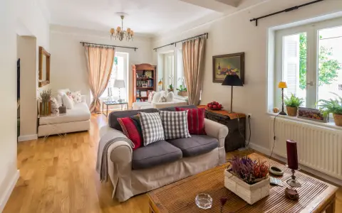 Przytulny salon w stylu angielskim z sofami, książkami i oknami.