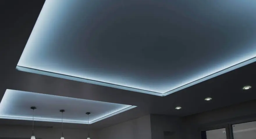 Nowoczesny sufit napinany z podświetleniem LED tworzy nastrojową atmosferę.