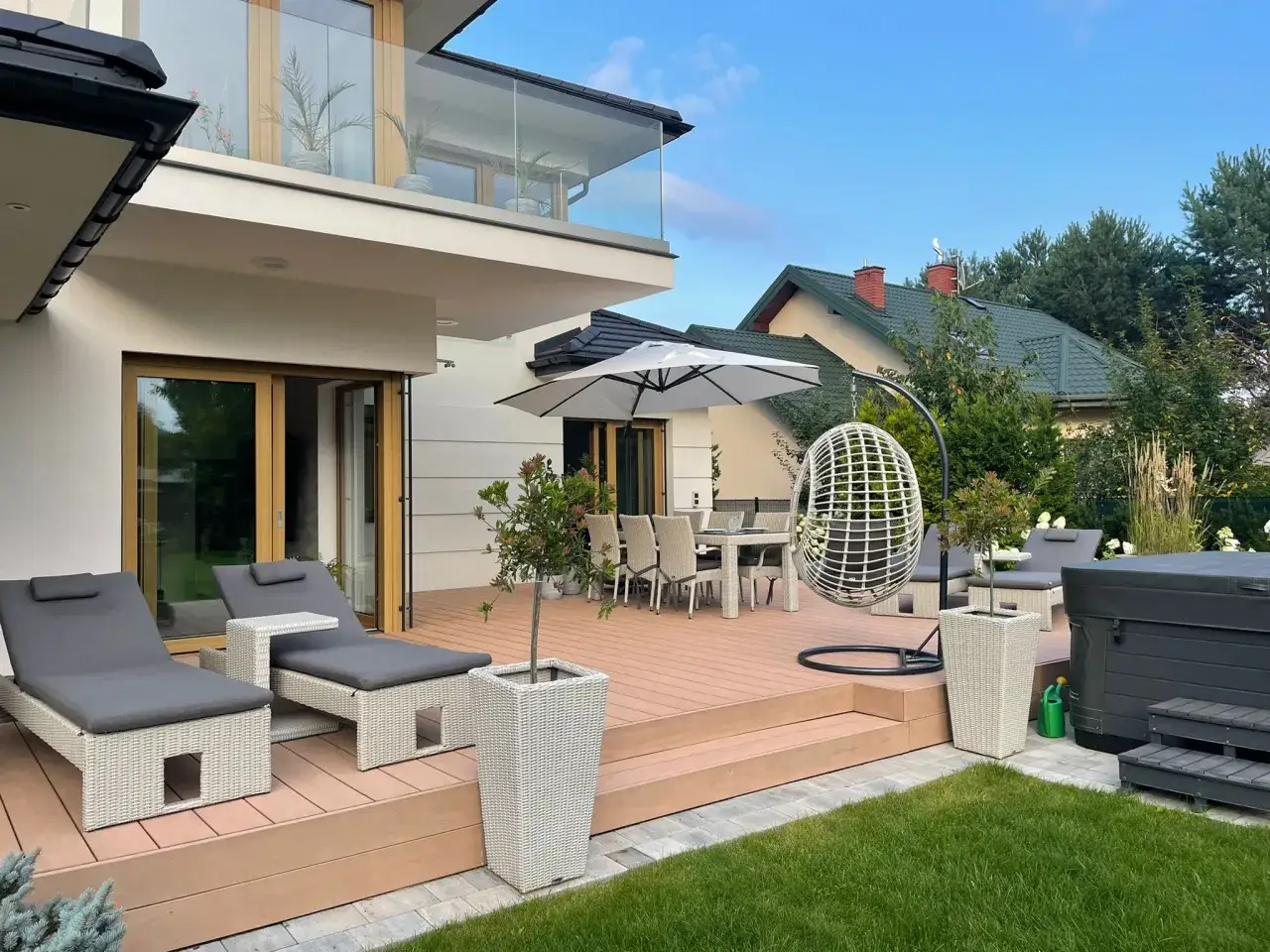 Nowoczesny patio z leżakami, stołem i krzesłami, idealne do relaksu. To jest właśnie patio, co to znaczy?