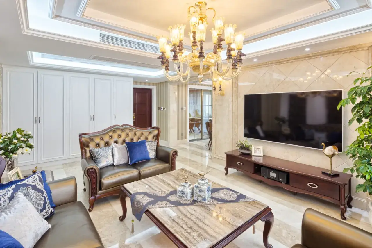 Elegancki salon z brązową sofą, marmurowym stolikiem i dekoracjami w kolorze kobaltowym.